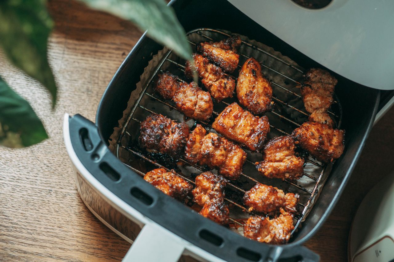 9 Air Fryer Winter Cooking Hacks to Make the Appliance Feel Like Its Brand New 10 Air fryer basket filled with crispy food on a kitchen countertop