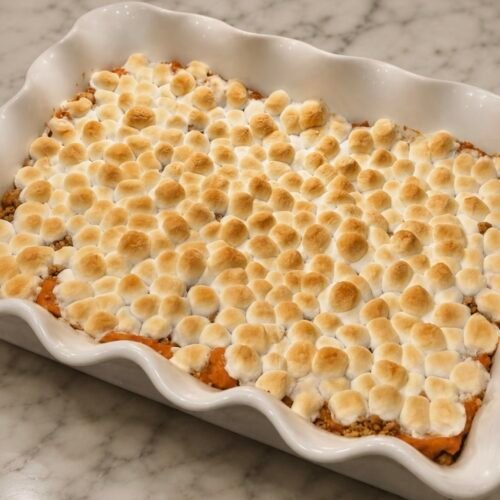 Sweet potato casserole topped with toasted marshmallows in a baking dish