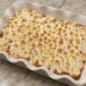 Sweet potato casserole topped with toasted marshmallows in a baking dish