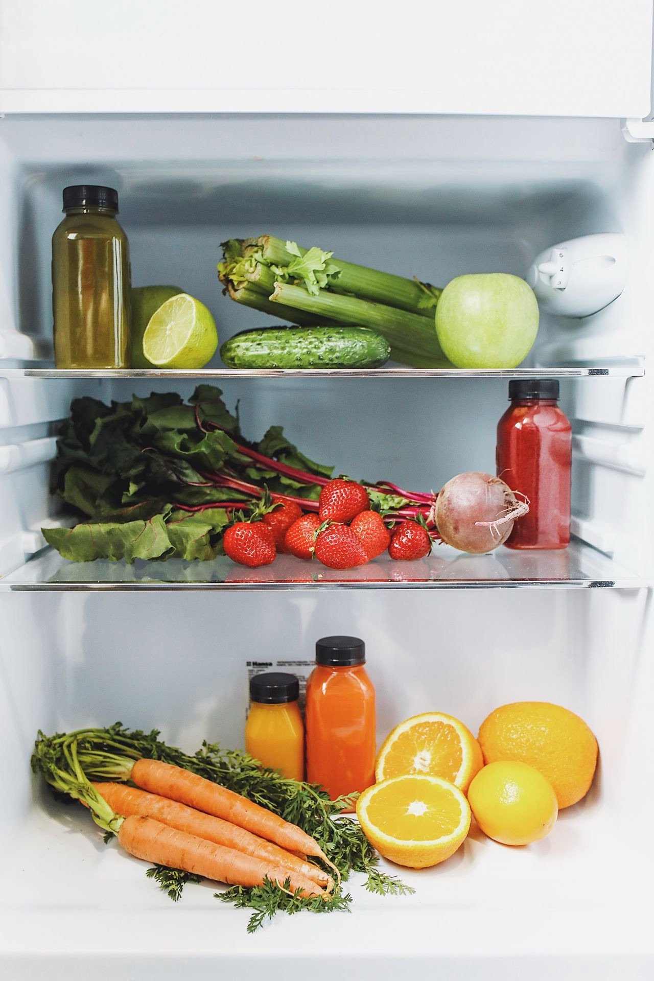 Fresh herbs and produce stored properly in the refrigerator to prevent spoilage