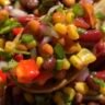 Mexican bean salad with pinto, black, and kidney beans, corn, bell pepper, and tomato in a cilantro-lime dressing