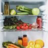 Fresh herbs and produce stored properly in the refrigerator to prevent spoilage