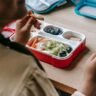 DIY adult lunchable box filled with protein, cheese, crackers, and fresh produce