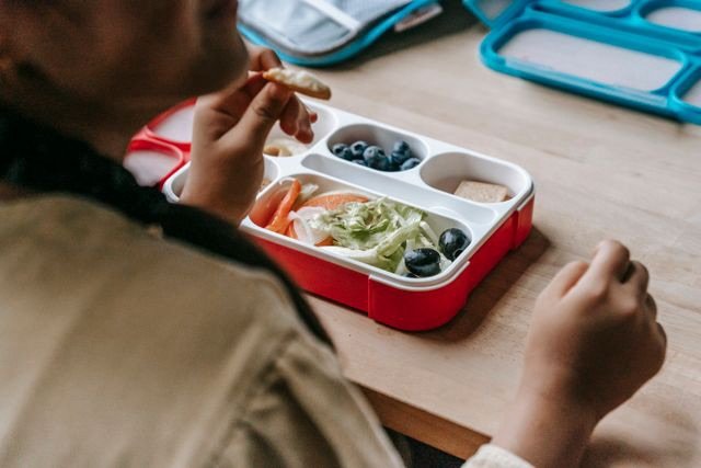 DIY adult lunchable box filled with protein, cheese, crackers, and fresh produce