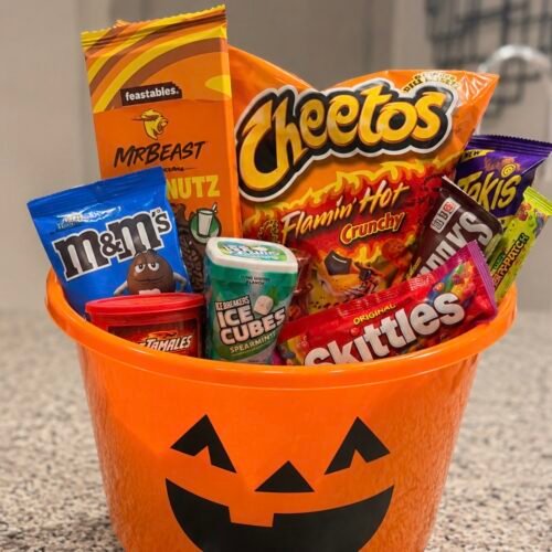 The Candy Charcuterie Boo Basket That's Taking Over Halloween 1 Halloween candy charcuterie board with chocolate bars, gummy worms, and candy corn arranged on a wooden tray