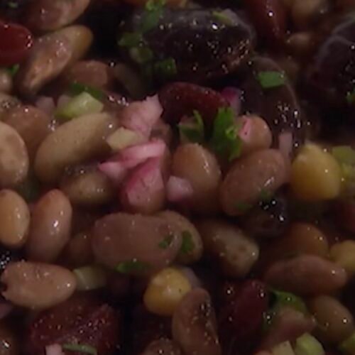 Seven bean salad in a bowl with black beans, chickpeas, cannellini beans, edamame, and lentils tossed in olive oil dressing