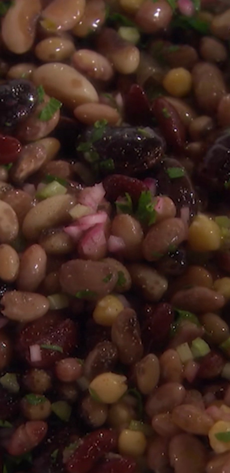 Seven bean salad in a bowl with black beans, chickpeas, cannellini beans, edamame, and lentils tossed in olive oil dressing